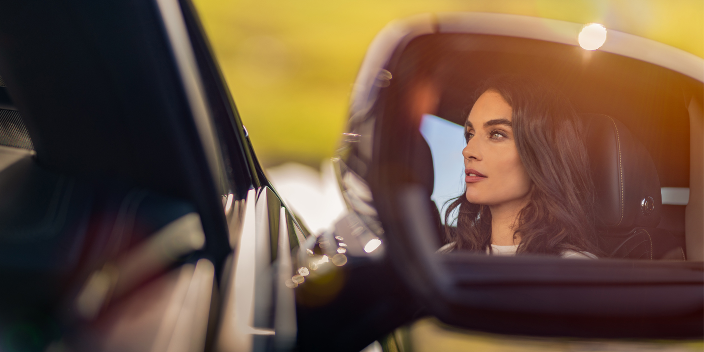 Bentley Sydney profile of dark haired woman's face in mirror of Bentley car in sunlight